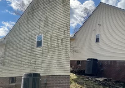 Side-by-side of a house before and after power washing, showing dirty and then clean siding under a blue sky.