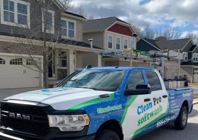 A Clean Pro Softwash truck is parked on a residential street in front of houses on a sunny day.