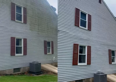 Side-by-side view of a house’s exterior before and after power washing, showing cleaner siding on the right.