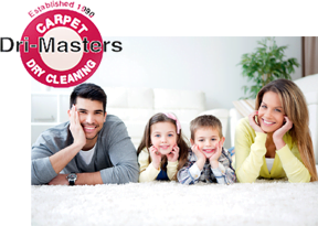A smiling family of four lies on a clean white carpet with a "Carpet Masters Dry Cleaning" logo in the corner.